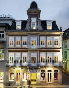 un vieux bâtiment avec une horloge en haut dans l'établissement Grande Hotel do Porto, à Porto