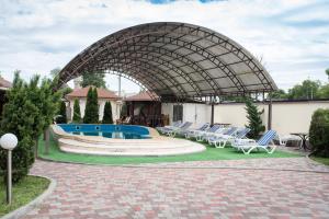 um pátio com espreguiçadeiras e uma piscina em Restoran-hotel Stariy Melnik em Poltava