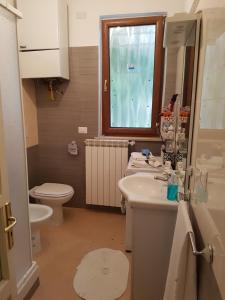 a bathroom with a sink and a toilet and a window at Casa Rosa in Montella