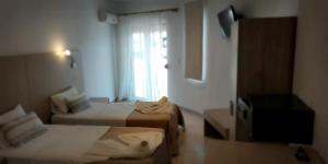 a hotel room with two beds and a television at Castello in Limenaria
