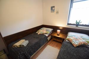 two beds in a small room with a window at Apartament Cztery Pory Roku Białka Tatrzańska in Białka Tatrzańska