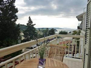 a wooden table with a vase of flowers on a balcony at Apartments Jani in Hvar