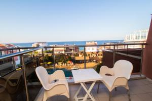 a balcony with a table and chairs and the ocean at Hotel Sunny in Sozopol