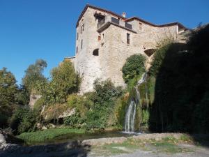 a castle with a waterfall in front of it at Le Cintrium in Viala-du-Tarn
