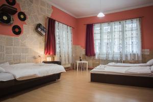 two beds in a room with red walls and windows at Serdika Rooms in Sofia