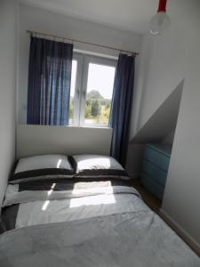 トシェンサチにあるMorski Domのベッドルーム1室(ベッド2台、窓付)