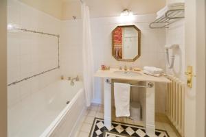 W łazience znajduje się umywalka, wanna i lustro. w obiekcie Chateau De Picomtal w mieście Crots