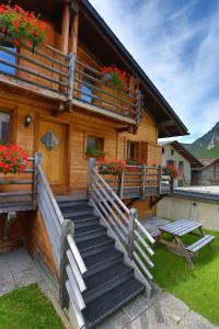 ein Holzhaus mit Treppen und Blumen darauf in der Unterkunft Chalet Mavambo in Le Châble