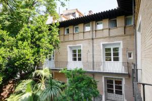 un edificio de apartamentos con balcón y árboles en My Way Away Suites, en Zaragoza