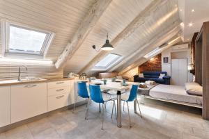 a kitchen and living room with a table and blue chairs at ACADAMIS - Loft dei Principini in Turin