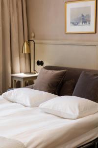 - une chambre avec deux lits et une table avec une lampe dans l'établissement Hotel Kungsträdgården, à Stockholm