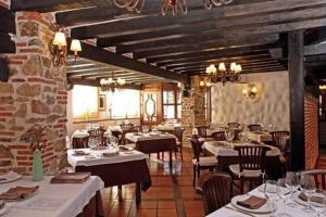 un restaurante con mesas y sillas en una habitación en Hotel Spa Villa de Mogarraz, en Mogarraz