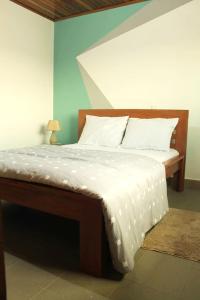 a bedroom with a bed with a white comforter at Princess Endale Residence in Douala
