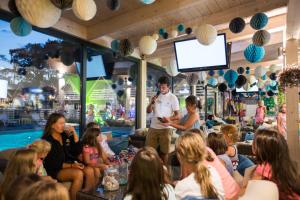 a man speaking to a crowd of people in a restaurant at Holiday Park & Resort Pobierowo - całodniowe animacje i podgrzewany basen w cenie in Pobierowo