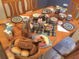 una mesa de madera con un plato de pan y una cesta de comida en Pension zur Wartburg, en Görlitz