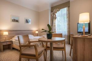 Televízia a/alebo spoločenská miestnosť v ubytovaní Hotel Cesarskie Ogrody