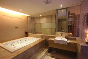 La grande salle de bains est pourvue d'une baignoire et d'un lavabo. dans l'établissement Venice Motel, à Kaohsiung
