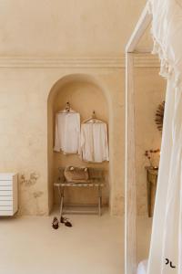 a room with two hangers with white shirts on them at Angolo del poeta suite in Matera +73 photos