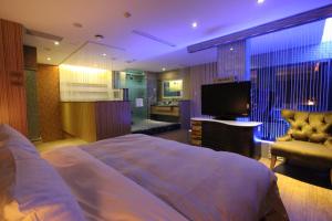 a bedroom with a bed and a flat screen tv at Venice Motel in Kaohsiung