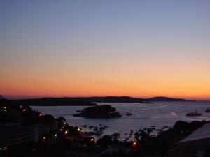 a sunset over the water with boats in it at Apartments Jani in Hvar