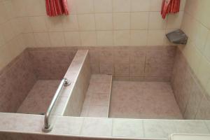 ducha con bañera y suelo de baldosa en Li Tang en Baihe
