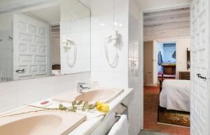 Un baño blanco con lavabo y espejo. en Els Caçadors de Maçanet, en Maçanet de Cabrenys