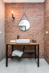 グダニスクにあるModern & Classy Industrial - Apartamenty Browar Gdańskのレンガの壁、洗面台付きのバスルーム