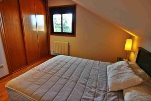 sypialnia z dużym łóżkiem i oknem w obiekcie Casa de O Rosal w mieście San Bartolomé +12 zdjęć