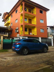 a blue car parked in front of a building at Princess Endale Residence in Douala