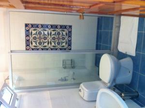 a bathroom with a toilet and a bath tub at Emel Pension in Guzelcamlı
