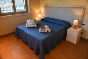 a bedroom with a blue bed with two pillows at Agriturismo L'Arte del Verde in Amelia