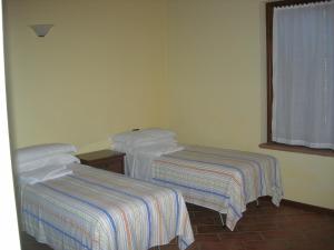 a hotel room with two beds and a window at Agriturismo Campass in Castelvetro Piacentino