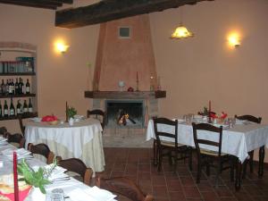 a dining room with two tables and a fireplace at Agriturismo Campass in Castelvetro Piacentino