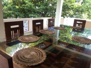 a glass table with tables and chairs on top of it at Kavindi Villa in Beruwala