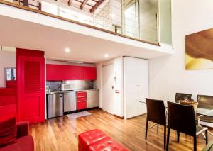 ローマにあるRSH Balestrari Apartmentsのキッチン(赤いキャビネット、テーブル、椅子付)
