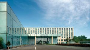 
a large building with a clock on the side of it at Cordis, Beijing Capital Airport By Langham Hospitality Group in Shunyi
