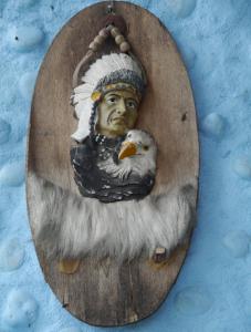 a statue of a head with a bird on a wooden plate at New Phiman Riverview Guesthouse in Bangkok