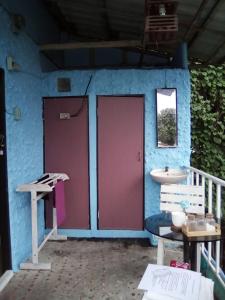 baño con 2 puertas rojas y lavamanos en New Phiman Riverview Guesthouse, en Bangkok