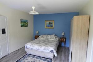 a bedroom with a bed and a blue wall at Domaine Du Moulin Neuf in Ambillou +8 photos