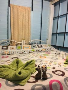 two cats sitting on a bed in a bedroom at New Phiman Riverview Guesthouse in Bangkok