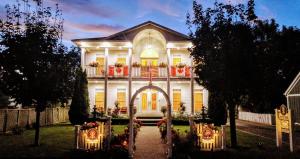 una gran casa blanca con un arco delante de ella en The White House Boutique B&B en Niagara on the Lake