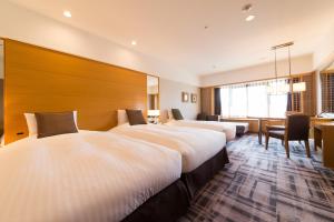 Postel nebo postele na pokoji v ubytování Kyoto Brighton Hotel