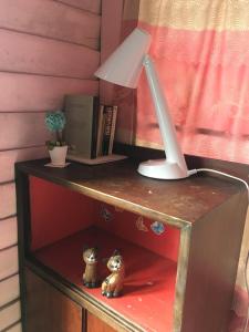 a desk with a lamp and two figurines on it at New Phiman Riverview Guesthouse in Bangkok