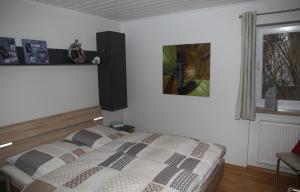 ZandtにあるFerienhaus Adeleのベッドルーム1室(ベッド1台付)が備わります。壁に絵が飾られています。