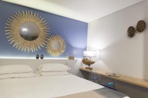 a bedroom with a bed and a mirror on the wall at Graviana - Pedra Azul Charming House in Lagoa