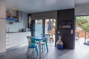 a kitchen with a blue table and some chairs at Graviana - Pedra Azul Charming House in Lagoa