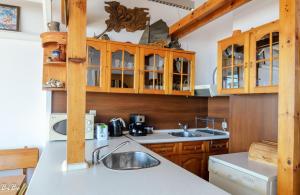 una cocina con armarios de madera y fregadero en Dom Mladenovi en Sozopol