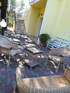 - un ensemble de chaises et de tables sur une terrasse dans l'établissement VillaOlivara, à Pizzo