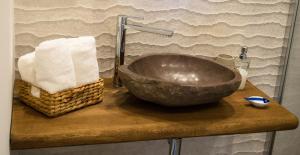 a bathroom sink with a stone bowl on a counter at S'accabbadora Guest House in Alghero