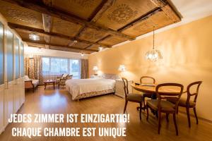 a bedroom with a bed and a table and chairs at Badehotel Salina Maris – Wellness & Vintage in Mörel